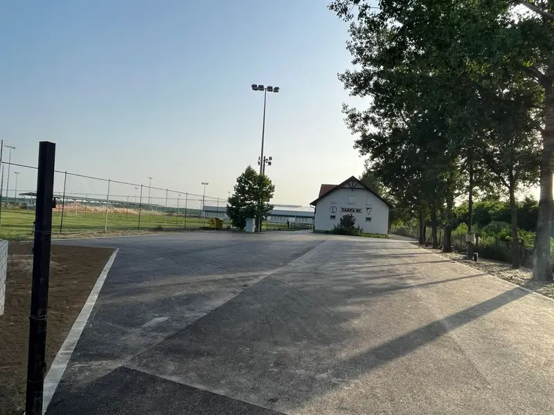 Elkészült aszfaltozott parkoló egy sportlétesítmény mellett